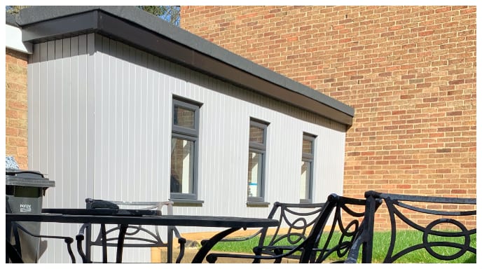 back yard with outdoor seating and barbecue with family next to our bespoke garden room gym